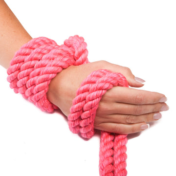 Hot Pink Twisted Cotton Bondage Rope by Knotty Desires tied around a hand.