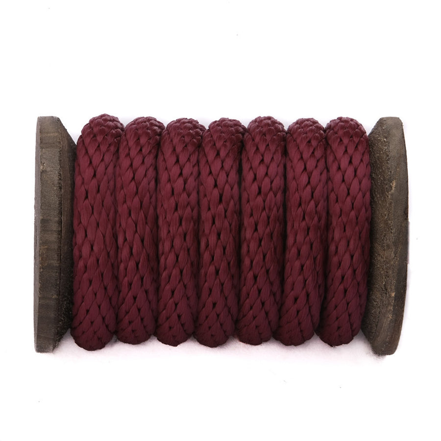 Knotty Desires burgundy polypropylene bondage rope on a spool.
